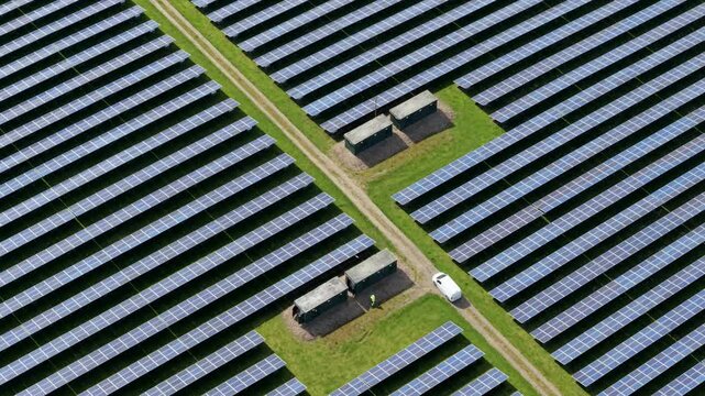 Aerial view of Tutbury solar energy farm with rows of solar panels and utility boxes in Tutbury, England, United Kingdom.