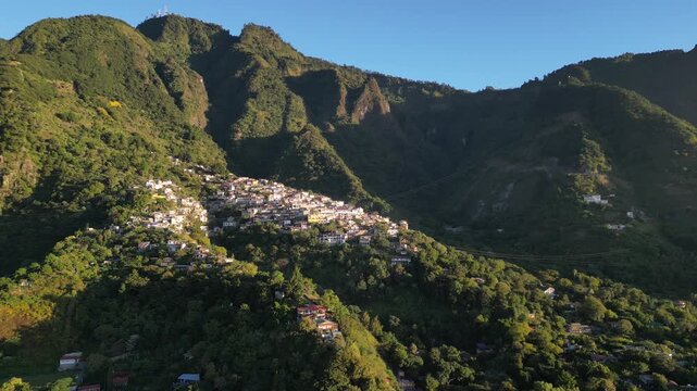 historic mayan village in lake atitlan guatemala (santa cruz la laguna) small homes maya residents side of mountain volcanic caldera volcano travel tourism poverty traditional native aerial