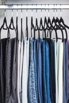 women trousers jeans and yoga pants in decluttered organized wardrobe