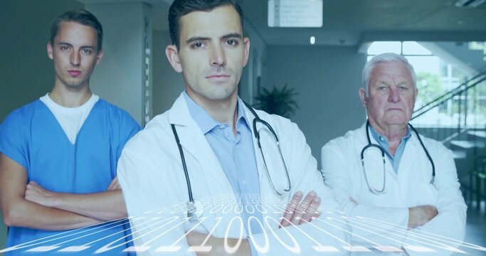 Standing center doctor crossing arms in clinic corridor with lab coats, blue scrubs, stethoscopes