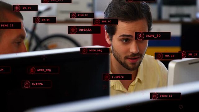 Receiving network data man in yellow shirt debugging monitors with red HUD overlaying screens