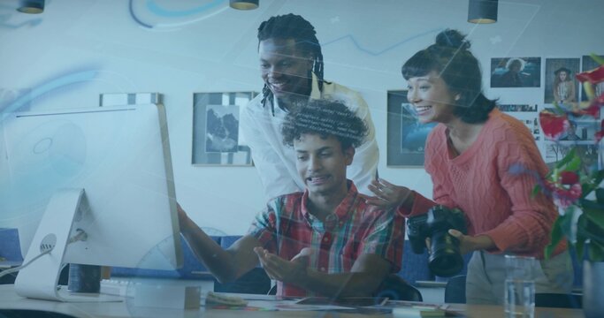 Gesturing team wearing coral sweater, plaid shirt reviewing data overlays on monitor, DSLR camera