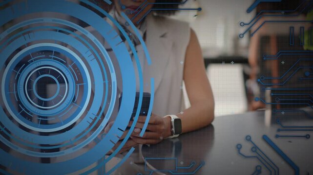 Woman picking up smartphone in coworking cafe with HUD graphics overlaying screen, testing app code