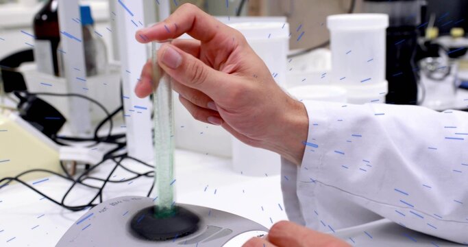 Lab technician hand, lab coat sleeve, inserting glass tube into mixer at lab bench, reagent jars