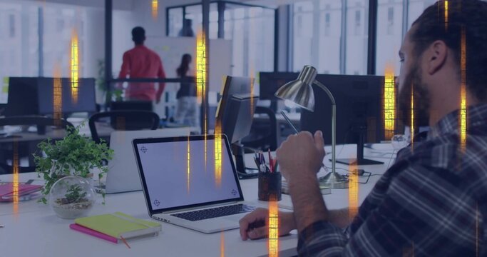 Working man wearing dark plaid shirt typing on laptop at open-plan office, terrarium, copy space