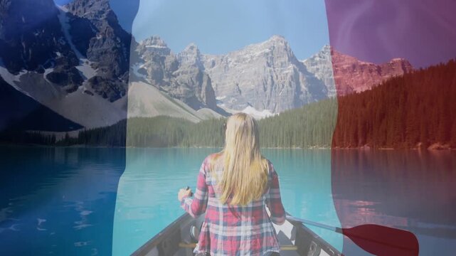 Travel paddler paddling canoe on turquoise lake while flag overlay drifting, showing heart