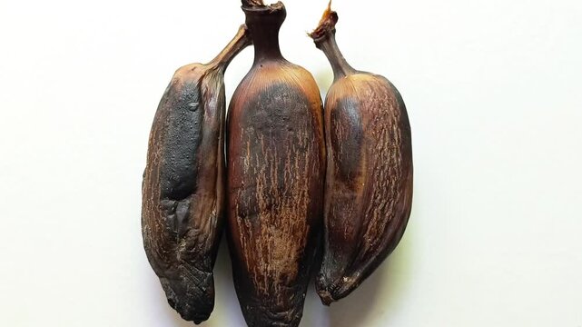 Three ripe roasted plantains musa x paradisiaca sweet cooked bananas isolated on white background