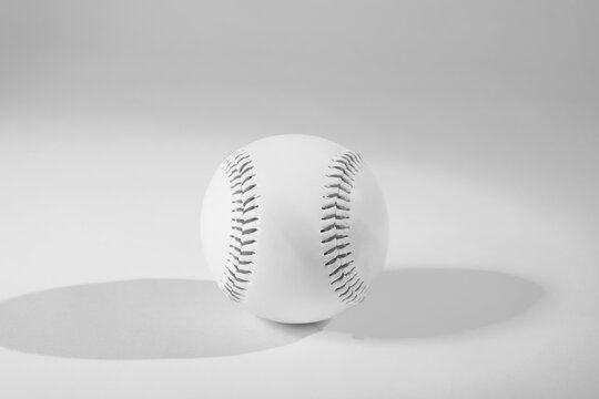 Modern and minimal baseball ball in black and white with copy space on empty background, sports concept.