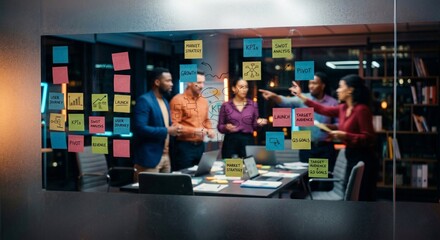 Obraz premium Creative professionals planning KPI and growth strategy on glass board with colorful sticky notes in modern office