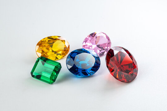 Colorful gemstone collection ruby red, sapphire blue, emerald green, topaz yellow and pink stones on white background, luxury jewelry concept, vibrant precious gems with brilliant sparkle