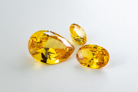 Yellow gemstone set featuring brilliant faceted topaz stones in pear and oval cuts on white background, luxury jewelry concept with sparkling clarity, vibrant golden gems for elegant design
