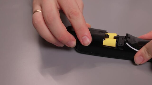 Instructional process of replacing battery in small electronic device. Comprehensive tutorial on inserting and securing battery within electronic device enclosure