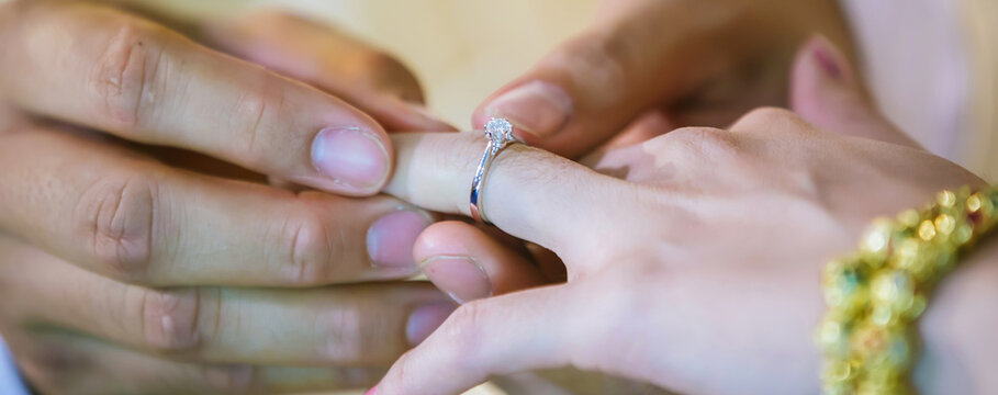 Groom show wedding ring on the box before give to bride in wedding ceremony.  Wedding rings. He Put the Wedding Ring on Her. 