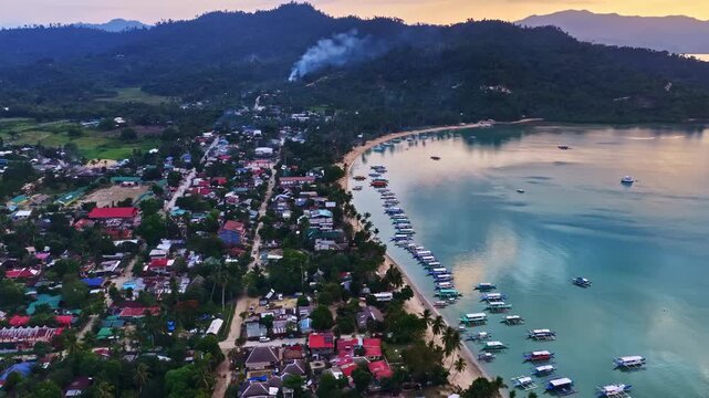 Bangka boats anchored in the calm bay of Port Barton at a sunset light