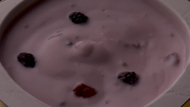 yogurt berries spoon stirring creamy texture closeup food photography healthy breakfast product shot organic fruits motion mix