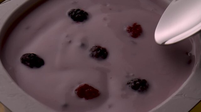 yogurt berries spoon stirring creamy texture closeup food photography healthy breakfast product shot organic fruits motion mix