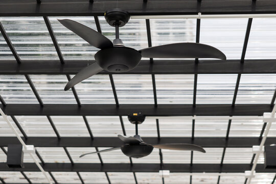 Modern glass roof with ceiling fans in motion