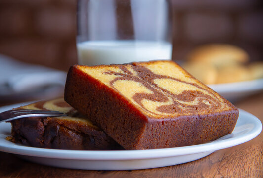 reposteria fina, pan dulce mexicano para desayuno postres o cenas en familia, tradicional. acercamiento o zoom a pan. panque marmoleado con vaso de leche fria al fondo