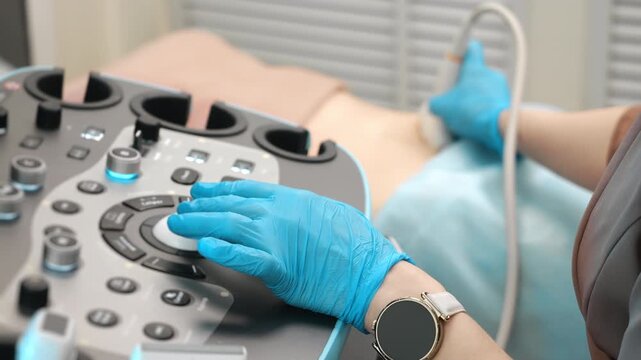 Doctor performing abdominal ultrasound scan using modern equipment in medical clinic diagnostic procedure and healthcare examination.
