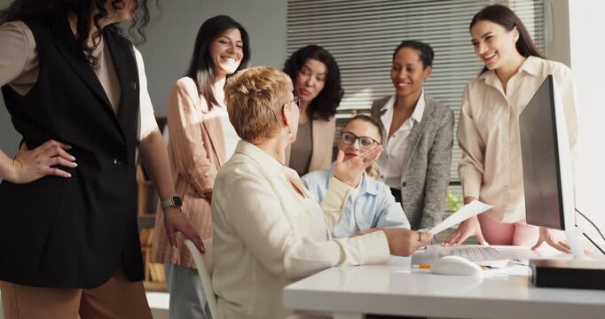 Women team meeting with leader and discussion. Colleagues gather at a computer in the office, reviewing documents with collaboration and aligning planning goals. Team focus and strategy theme.