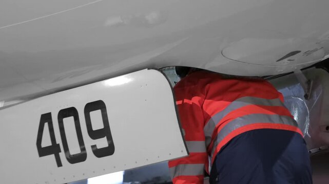 Airplane aircraft landing gear technic man inspection. Airport terminal technician worker man airline maintenance ground crew aircraft. Safety at evening night.