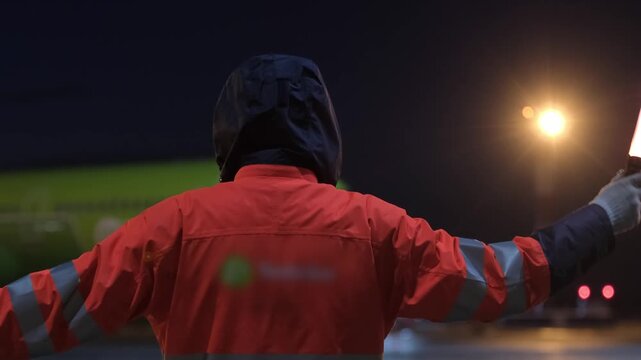 Airplane at night evening marshaling airfield runway. Airport terminal maintenance ground crew aircraft. Preparing for departure takeoff. Safety. Technician worker marshalls man.