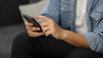 Close Up of Hands Using a Smartphone While Sitting on a Couch