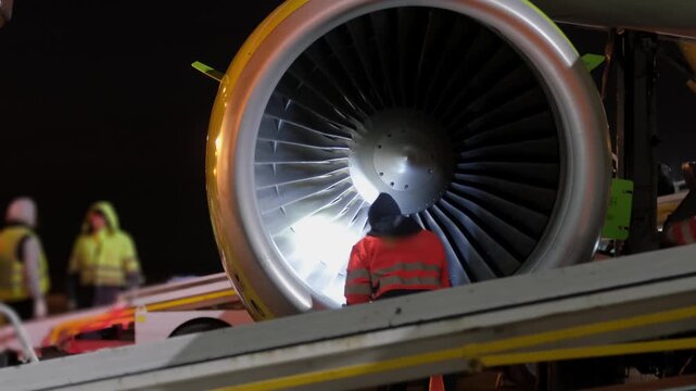 Airplane jet aircraft engine technic man inspection. Airport terminal technician worker man airline maintenance ground crew aircraft. Safety at evening night.