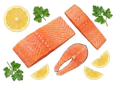 Fresh raw salmon fillets and steak cuts, arranged with bright yellow lemon slices and vibrant green parsley.