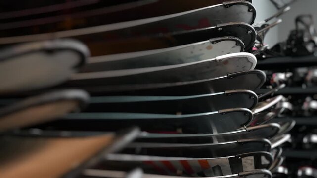 Rows of snowboards in ski resort rental shop equipment storage winter sports gear selection indoors shallow depth of field.