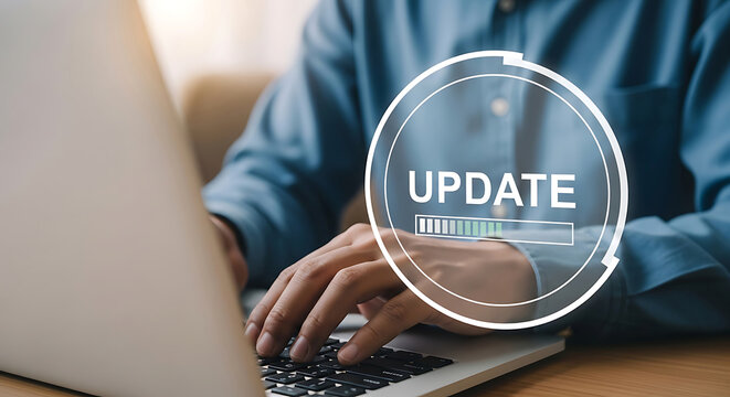 A business professional typing on a silver laptop with a digital overlay showing software update progress bar in a bright office environment during work hours