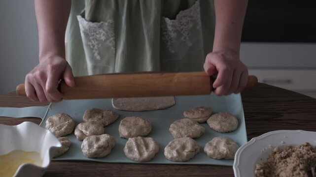 A woman is preparing dough for cookies