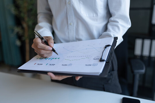 Businessman standing chekking documents with pen
