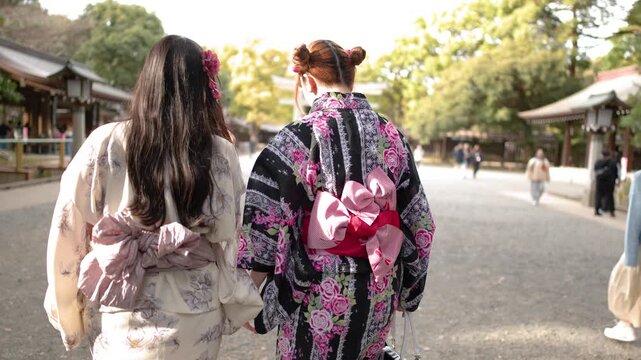 Two Women in Traditional Kimonos Walking Through Meiji Jingu Shrine