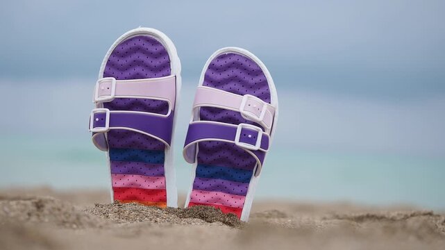 Bright sandals on sandy beach at summer time