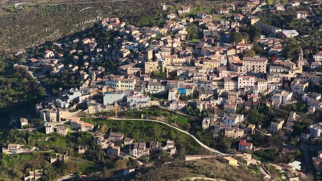Aerial view of the historic hilltop town with its medieval architecture and stone buildings nestled in the rolling hills of Capestrano, Abruzzo, Italy.