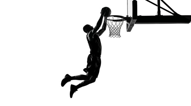 Silhouette of a basketball player dunking a ball into the hoop