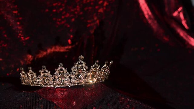 Golden crown on red glitter background with copy space, luxury festive design backdrop.
Elegant golden crown with sparkling gemstones on a red glitter background with copy space. 