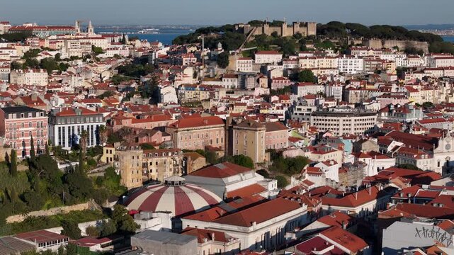 Aerial view of Sao Jorge Castle and the historic Alfama district with traditional red rooftops under a clear blue sky in Lisbon, Lisbon, Portugal.