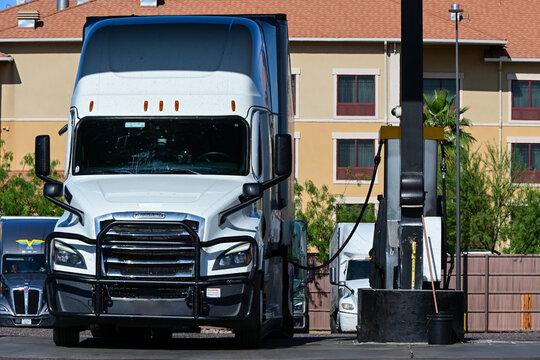 Semi truck parked at a truck stop fuel island, representing long haul transportation, diesel refueling, and roadside logistics services