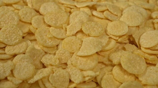 Panning across dry corn flakes texture macro view of breakfast cereal food