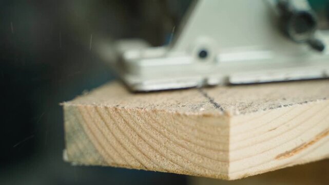 Close-up of cutting wooden board with electric saw