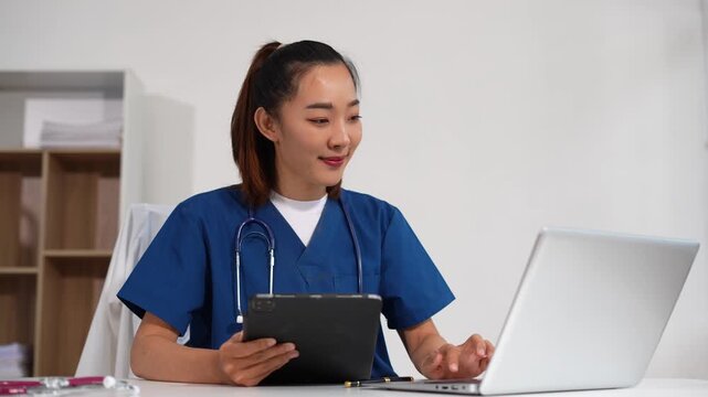 Female medicine doctor, physician or practitioner in lab room writing on blank notebook and work on laptop computer with medical stethoscope on the desk at hospital. Medic tech concept.