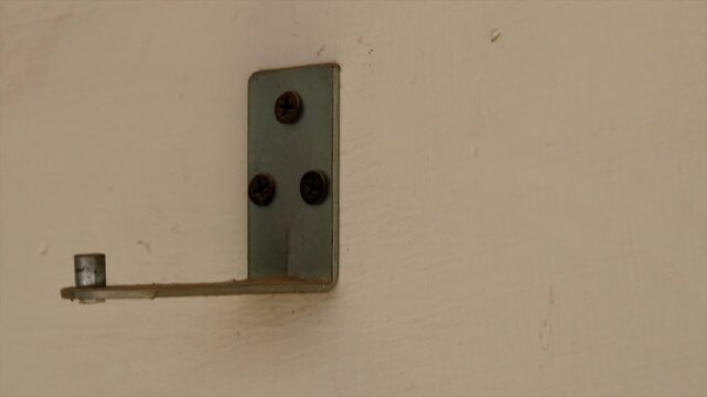 Close up of wall hook Close up of a modern black metal hook mounted on a textured concrete wall 4k