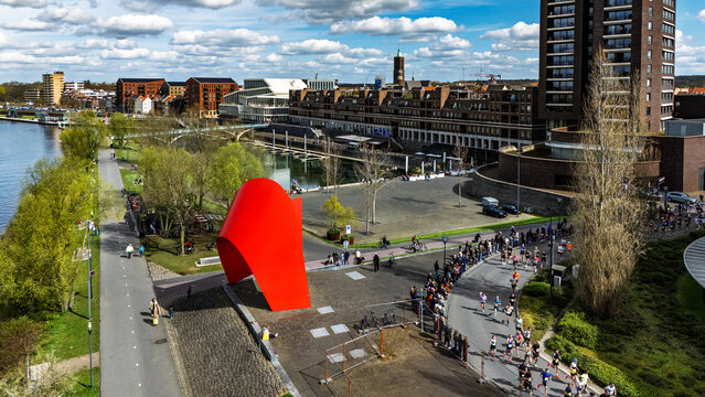 Aerial drone view of people running half marathon Venloop race in city, crowd runners on road racing sport competition, top-down view of athletes and spectators, Venlo, the Netherlands
