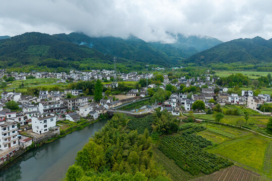 An aerial view shows the traditional houses and landscape of the ancient Hongcun village located in Yixian County of Anhui Province in China with mountains in the background
