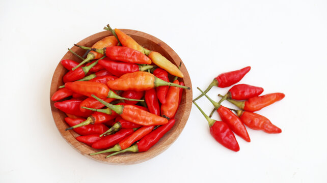 Red cayenne pepper (cabe rawit merah) on wooden bowl isolated on white background	