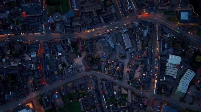 Aerial view of the town center at dusk with street lights and cars on the roads in Oakham, England, United Kingdom.