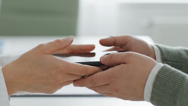 Close Up of Hands Passing Blank Smartphone Device