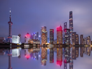 Obraz premium Shanghai colorful skyline with motion speed light of passing ferry in the foreground at night - Shanghai, China
